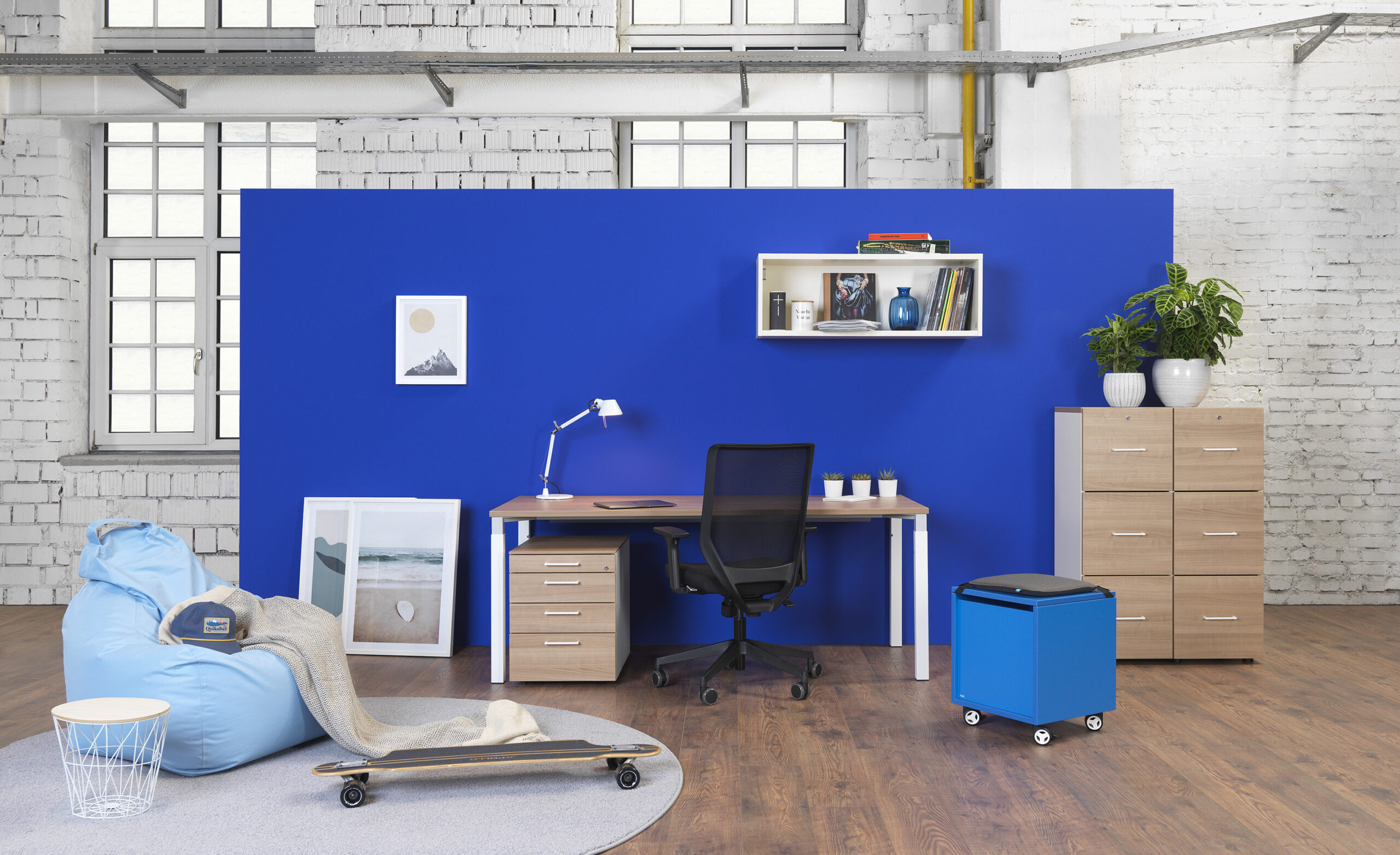 Büroszene mit Schreibtisch s120, Rollcontainern, Regalen und gelber Wand